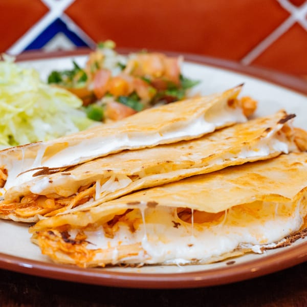 Frida Cantina's cheesy quesadillas with shredded chicken, served with lettuce and pico de gallo.