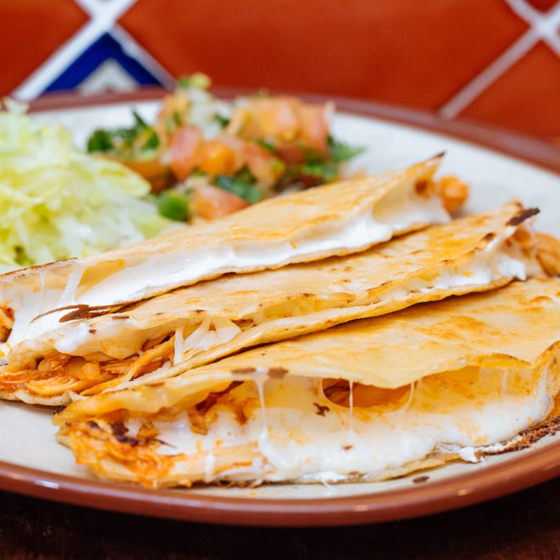 Frida Cantina's cheesy quesadillas with shredded chicken, served with lettuce and pico de gallo.